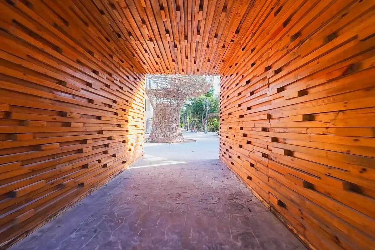 Túnel de madera con escultura al fondo