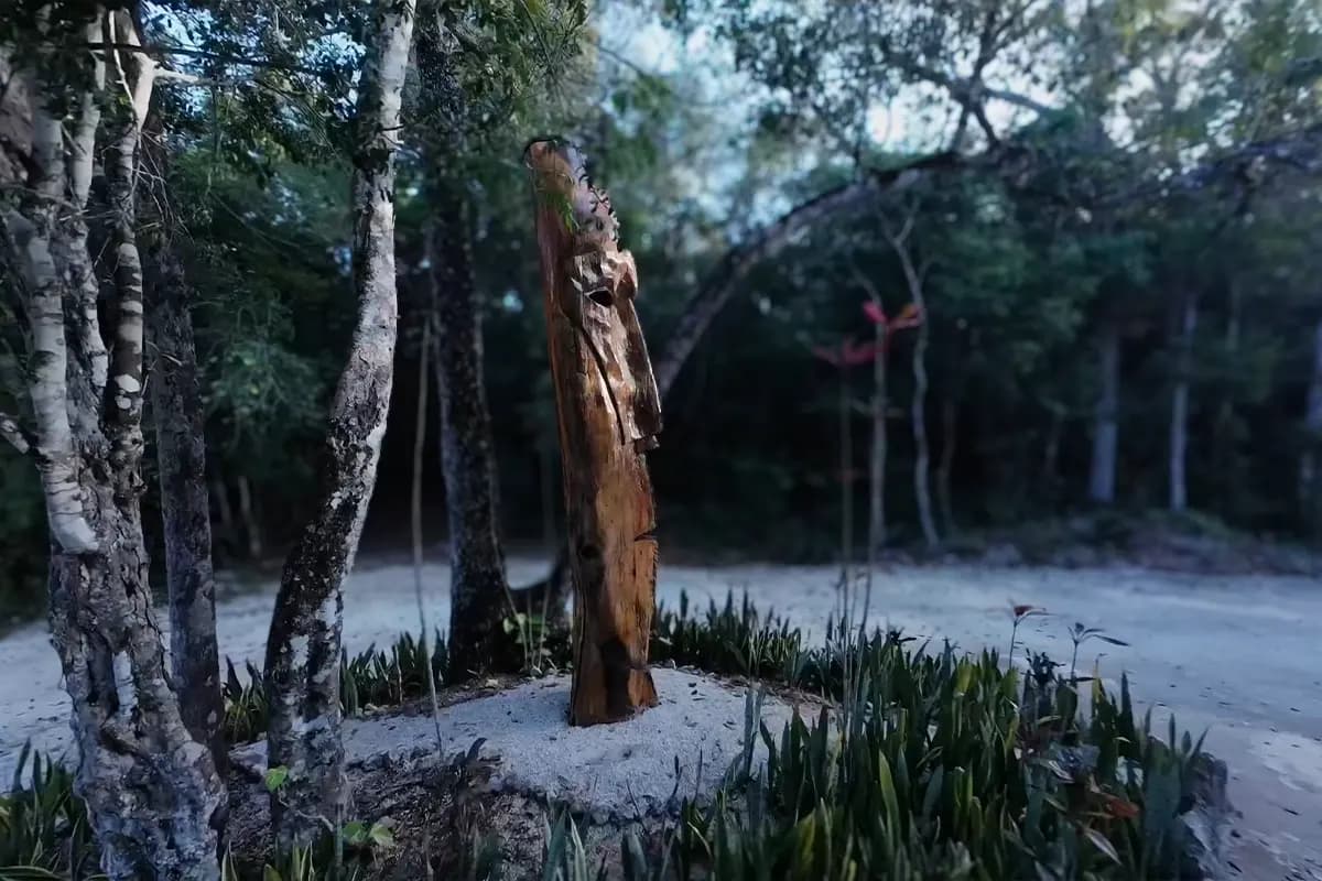 Escultura tallada en madera entre árboles